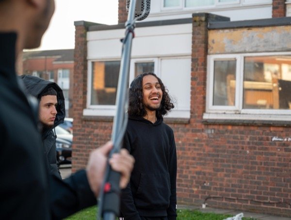 Production crew on location with boom mic during outdoor film shoot