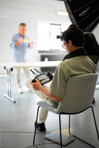 Director operating camera monitor during studio interview shoot
