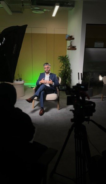 Filming corporate interview in studio with green screen and professional lighting